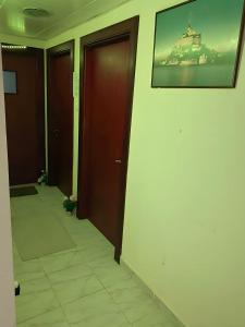 einen Flur mit zwei Türen und einem Bild an der Wand in der Unterkunft MBZ - Relax Room in Unique Flat in Abu Dhabi