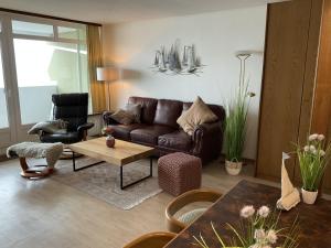 - un salon avec un canapé et des fauteuils en cuir brun dans l'établissement Panorama Whg 111, 8 OG, à Cuxhaven