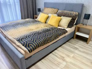 a bedroom with a large bed with yellow pillows at Apartman De lux 85m2 in Bojnice