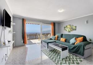 sala de estar con sofá verde y TV en Tabaiba Sunset sea Views en Santa Cruz de Tenerife