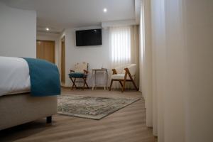 a bedroom with a bed and a table with chairs at Loureiro B&B in São Pedro do Sul +18 photos