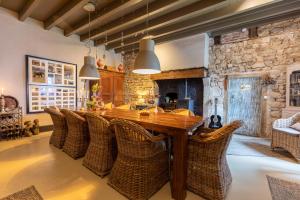 cocina grande con mesa de madera y sillas de mimbre en Domaine La Pomme de Pin, en Louroux-de-Beaune