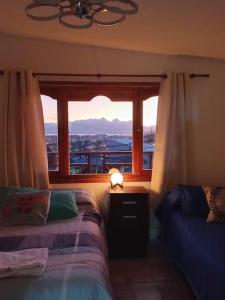 um quarto com uma cama e uma janela com vista em Ushuaia magnífica, cabaña 3 dormitorios em Ushuaia