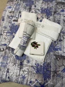 einen Haufen Handtücher und ein Buch auf einem Bett in der Unterkunft Popi al mare in villa con giardino e wifi in Sestri Levante