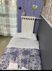 ein kleines Bett in einem Zimmer mit einem Heizkörper in der Unterkunft Popi al mare in villa con giardino e wifi in Sestri Levante