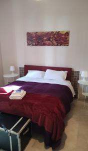 a bedroom with a large bed with a red blanket at Gira Guest House in Como
