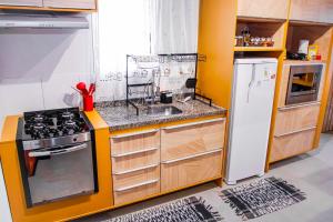 a kitchen with a stove and a refrigerator at Apartamento Aconchegante próximo ao Shopping Pantanal in Cuiabá
