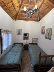 twee bedden in een kamer met een houten plafond bij Dameli in Sykaminéa