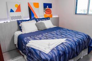 a bedroom with a bed with a blue comforter at Apartamento Aconchegante próximo ao Shopping Pantanal in Cuiabá