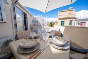 a table with plates and glasses on a balcony at Casa Vacanze RetroScena in Avola