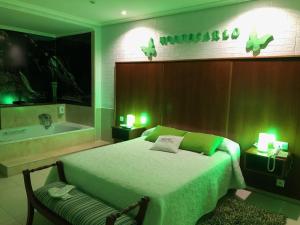 1 dormitorio con 1 cama y bañera con luces verdes en Motel Montecarlo, en Lugo