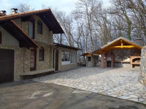 ein Haus mit einer steinernen Einfahrt neben einem Gebäude in der Unterkunft Vila sumska idila in Banja Koviljača