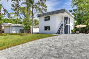 a white house with a driveway at Coastal Sarasota Condo Minutes to Beach! in Sarasota