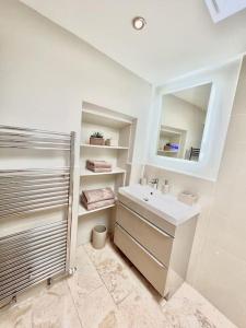 a white bathroom with a sink and a mirror at Treetops Cottage at Treetops Hideouts in Richmond