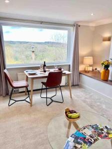 un soggiorno con tavolo, sedie e una finestra di Treetops Cottage at Treetops Hideouts a Richmond
