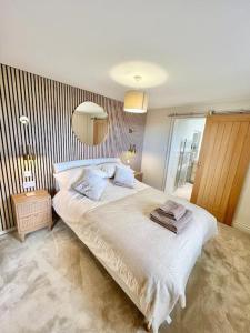 a bedroom with a large white bed with a mirror at Treetops Cottage at Treetops Hideouts in Richmond