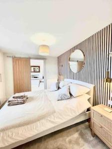 un letto bianco in una stanza con specchio di Treetops Cottage at Treetops Hideouts a Richmond Altre 17 foto