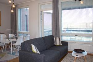 uma sala de estar com um sofá e uma mesa em MM City Apartment Ratina Close to Arena em Tampere