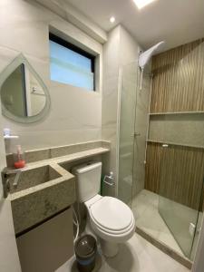 uma casa de banho com um WC e uma cabina de duche em vidro. em Flat mar Porto de Galinhas em Porto de Galinhas