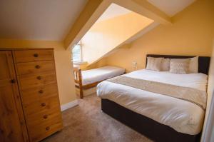 sypialnia z łóżkiem i komodą na poddaszu w obiekcie WV Top Flat Bowness Center w mieście Bowness-on-Windermere