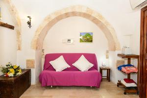 a purple couch in a room with an archway at Masseria Pozzo Tre Pile in Martina Franca +93 photos