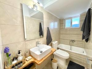 a bathroom with a sink and a toilet and a tub at KAPA Central Apartment in Kalamata