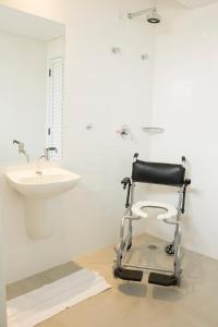 a black wheelchair in a bathroom with a sink at Hotel Real Executive in Aparecida de Goiânia