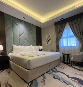 a bedroom with a large bed and a large window at فندق الوتين ALwateen Hotel in AlUla