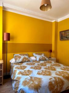 アヴィニョンにあるChez Colacのベッドルーム1室(黄色い壁、大型ベッド1台付)