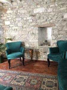 a living room with two chairs and a stone wall at Urla bir nefes taş ev in Urla