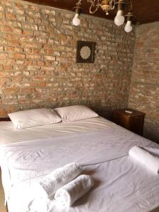 a bed in a brick room with two towels on it at Urla bir nefes taş ev in Urla