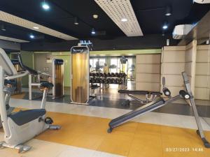 een fitnessruimte met loopbanden en fitnessapparatuur in een gebouw bij Larue cozy room in Solemare Parksuites Paranaque in Manilla