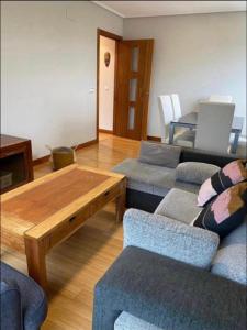 un soggiorno con 2 divani e un tavolo in legno di TORRES DE MONTENUÑO a Oviedo