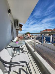a balcony with a table and a view of the water at MT APARTMENTS in Neoi Epivates