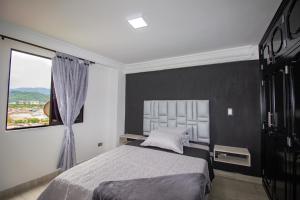 Un dormitorio con una cama grande y una ventana en Excelente apartamento cerca a parques turísticos, en Medellín