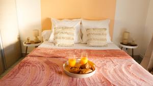 een bed met een kom brood en twee glazen sinaasappelsap bij T2 Prestige L'Oasis Des Nomades - Résidence ARKEA in Saint-Denis