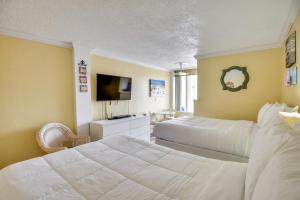 a hotel room with two beds and a television at Daytona Beach Studio with Private Lanai 1 Mi to Pier in Daytona Beach