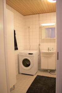 een badkamer met een wasmachine en een wastafel bij MM City Apartment Ratina Close to Arena in Tampere
