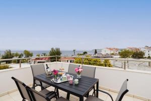 a table on a balcony with a view of the ocean at Marilena Mare Seaside House in Ialyssos