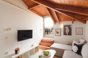 a living room with a couch and a tv at Marilena Mare Seaside House in Ialysos