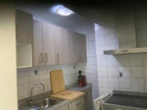 a kitchen with white cabinets and a sink at Es Pujols isla de la Calma in Es Pujols