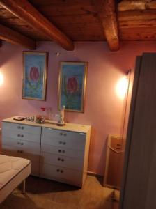une salle de bains pourvue d'une commode avec un lavabo et de 2 photos sur le mur. dans l'établissement Semina-Marina, à Chersónissos