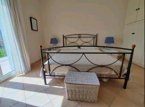 een slaapkamer met een bed met een smeedijzeren frame bij Sunny Coco mat villa in Katelios with a sea view in Kateliós