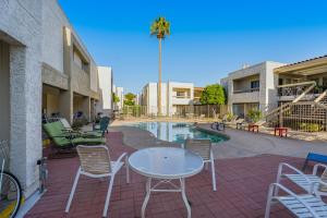 a patio with a table and chairs next to a pool at Sunbeam Condo in Scottsdale