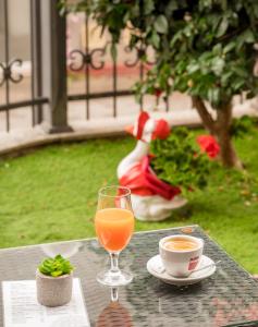 een glas sinaasappelsap en een kopje koffie op een tafel bij Garni Hotel MB in Budva
