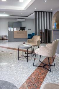 a lobby with two chairs and a table and a counter at Garni Hotel MB in Budva