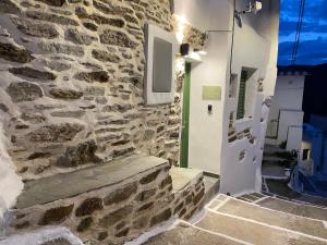 a stone wall with a green door and stairs at Dryopis Studio in Dhriopís
