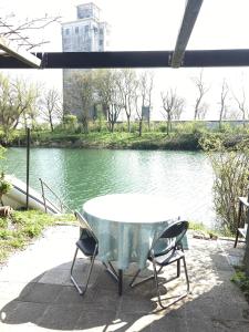 una mesa y sillas sentadas junto a un río en TIJ Tiny house aan het getijdewater in Zierikzee en Zierikzee