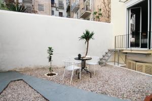 a small courtyard with a table and chairs on a white wall at Patio Apartment near metro & Acropolis in Athens
