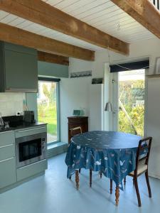 a kitchen with a table with a blue table cloth on it at TIJ Tiny house aan het getijdewater in Zierikzee in Zierikzee
